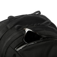 Black backpack with sunglasses inside on a white background