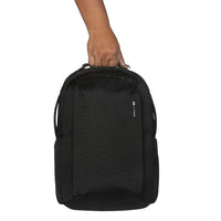 Black backpack held by a person on a white background