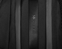 Close-up of a black backpack with a brand logo on the fabric.