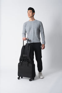 Man holding a black suitcase against a white background