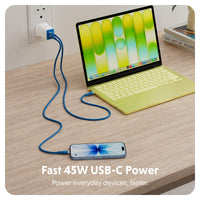 A blue USB-C cable shown plugging into a wall outlet and connecting to a laptop and smartphone on a wooden desk, with text reading 'Fast 45W USB-C Power' and 'Power everyday devices, faster.'.