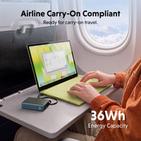 portable powerbank being used on airplane to charge a macbook device
