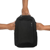 Black backpack held by two hands on a white background