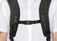 Black backpack straps on a person wearing a white shirt