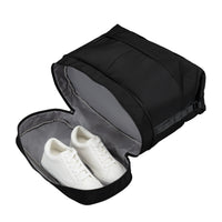 A black shoe bag with a gray interior, shown open with a pair of white sneakers inside, on a plain white background.