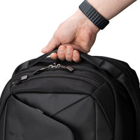 Black backpack held by a hand with a white background