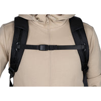 Person wearing a beige jacket with a black backpack on a white background