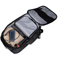 Open black backpack with compartments and items on a white background