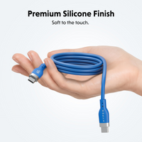 A coiled blue USB-C cable with a matte silicone finish is held in a hand against a light gray background. Text at the top reads 'Premium Silicone Finish' and 'Soft to the touch.